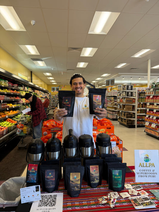 Allpa Foods founder Elias Burrell smiling and holding Peruvian cacao powder and maca root powder at the Takoma Park Silver Spring Co-op launch